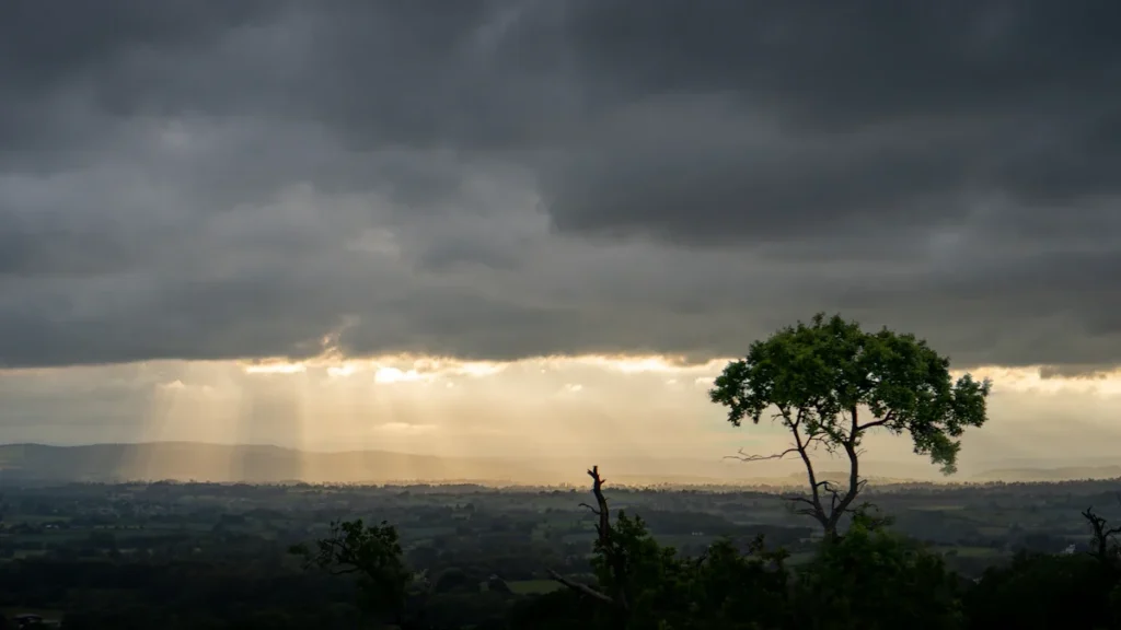 Moody sunset with crepuscular rays over the vast, rolling hills of rural Shropshire.
