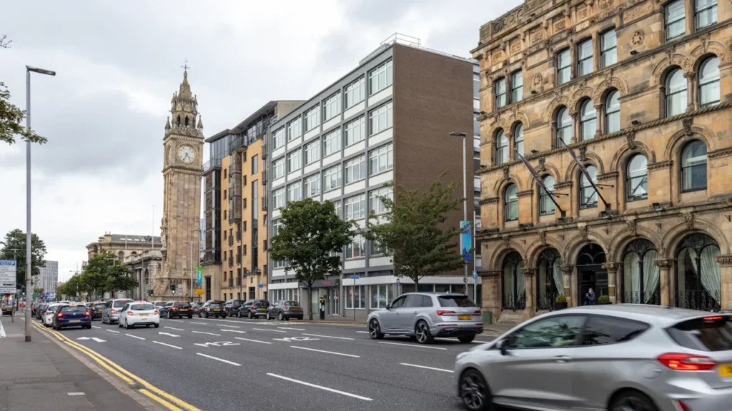 Street scene with cars in Belfast city centre under a grey, overcast sky.