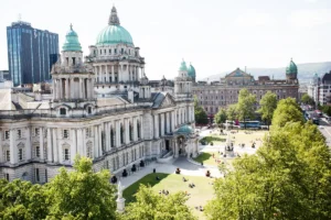 High-angle view of Belfast City Hall with green dome and surrounding public gardens.