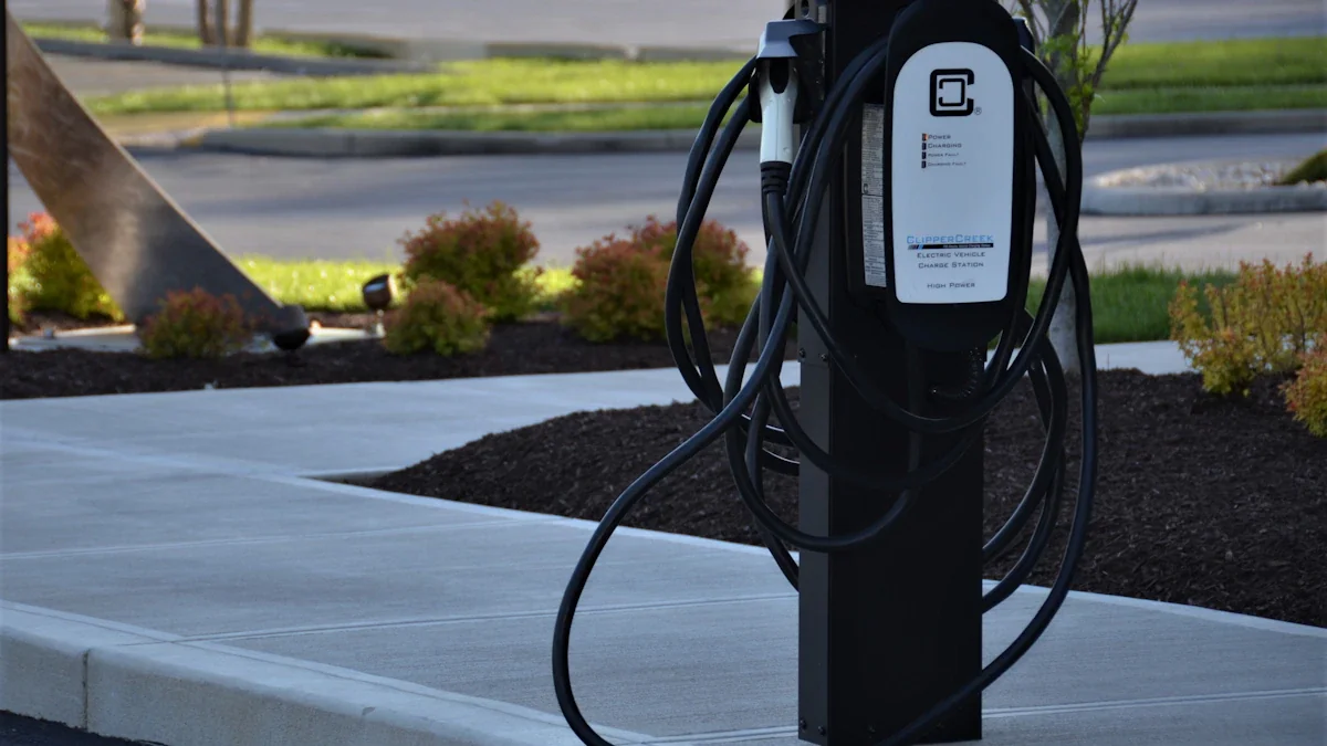 A black electric vehicle charging station standing on a concrete sidewalk.