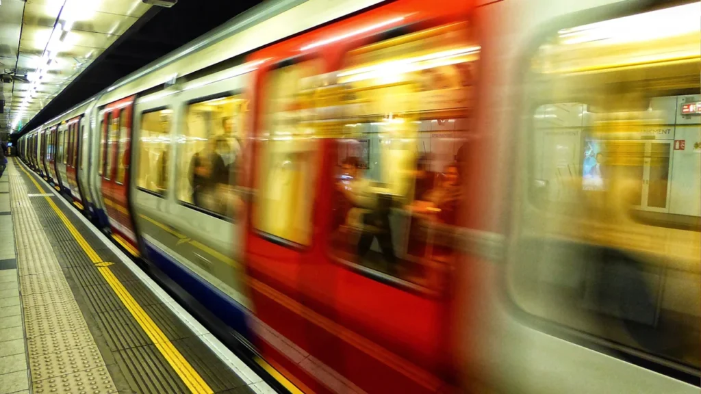 London underground train arriving at the platform with blurred motion, viewed from the side.