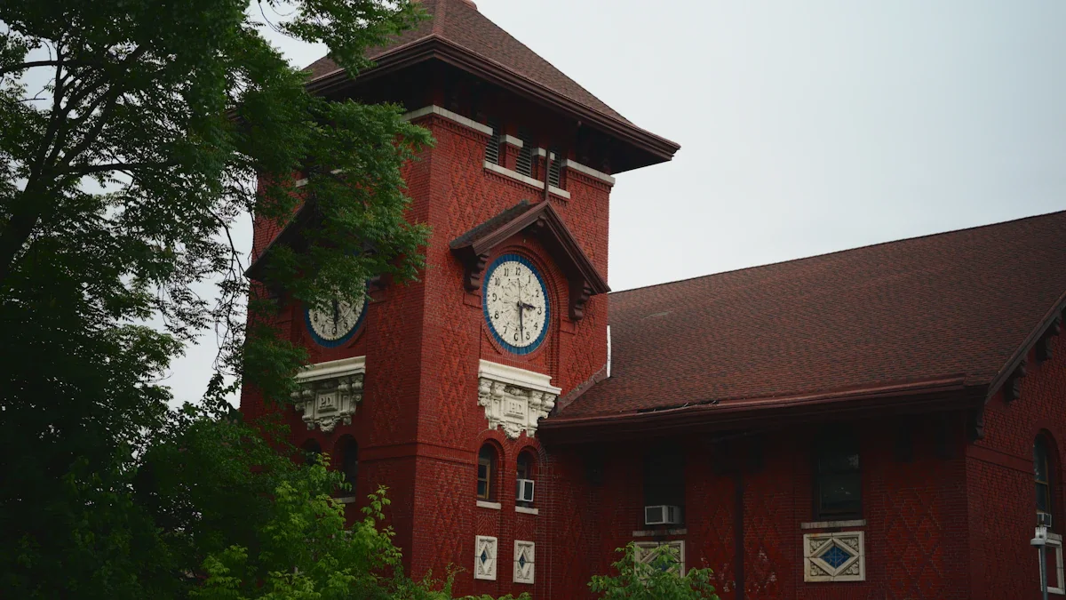 Red brick building with a historic clock tower and surrounding green trees.
