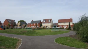 Modern suburban housing development built on the edge of green space in the UK.