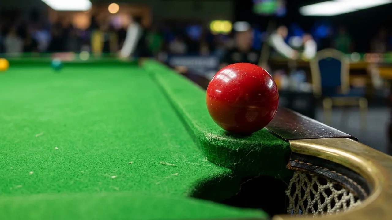 A close-up of a red snooker ball sitting near the corner pocket on green felt.