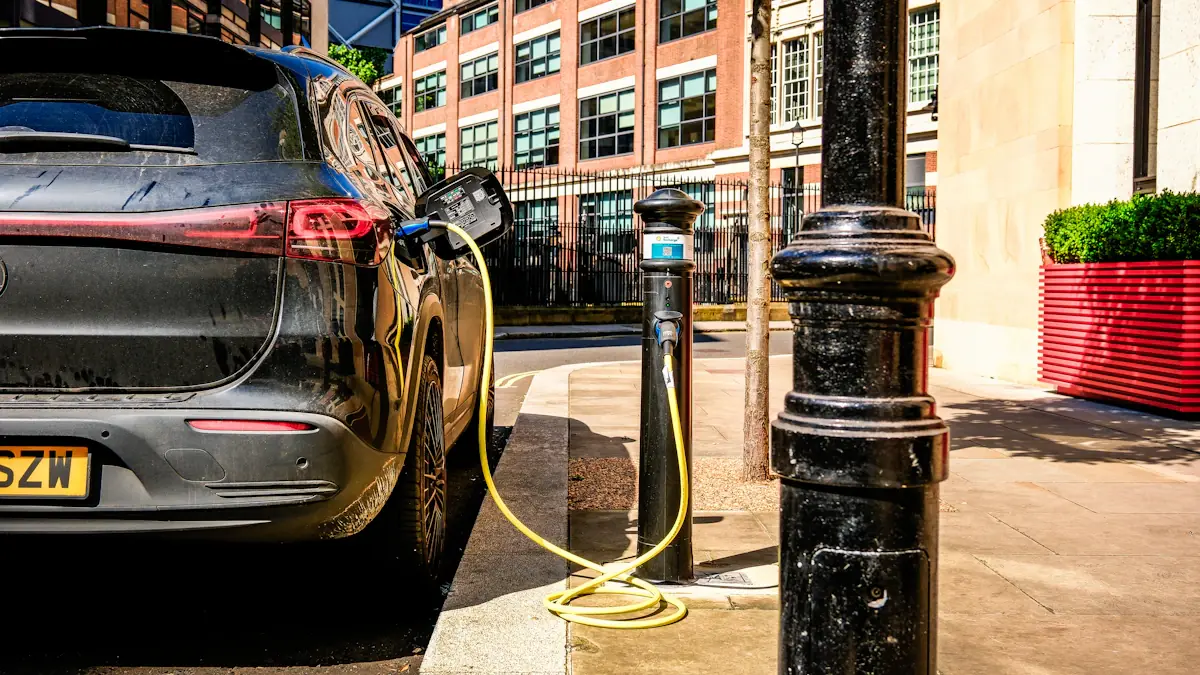 A black electric car charging at a public station on a city street.