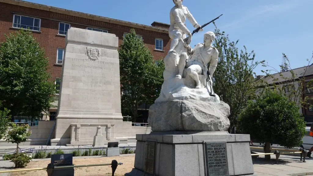 A stone war memorial featuring a statue of two soldiers standing on a rock.