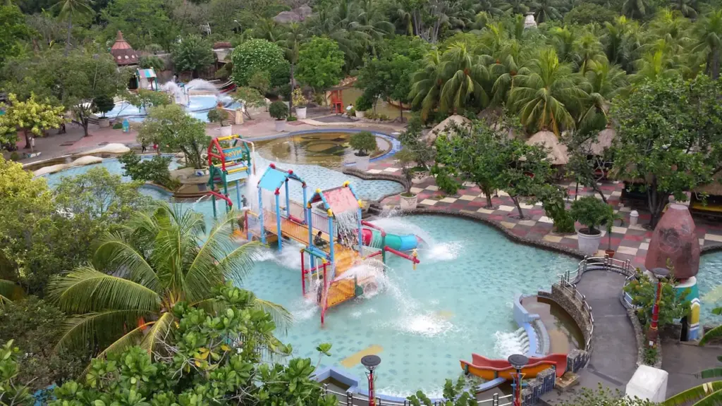 Aerial view of a public swimming pool and surrounding splash park facilities.
