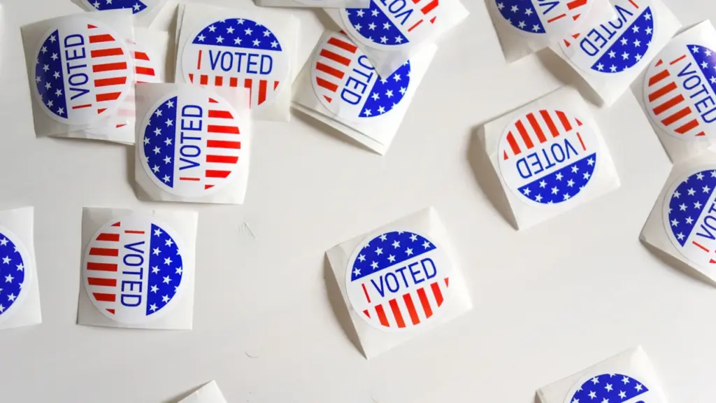 Several I Voted stickers scattered on a clean white surface for administrative review.