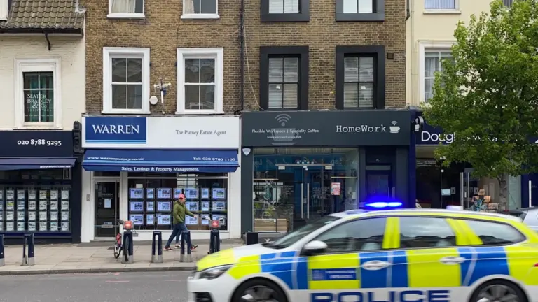 Metropolitan Police car responding to an emergency on a London street during the day.