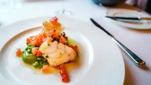 Professional gourmet fish dish served on a white ceramic plate in London