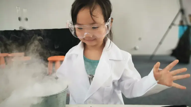 A young girl in a lab coat and goggles conducting science experiments.