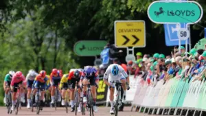 A professional cyclist leads a pack of riders during a competitive road cycling race.
