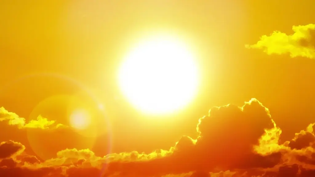 A brilliant white sun shines brightly against a vibrant orange and yellow cloudy sky.