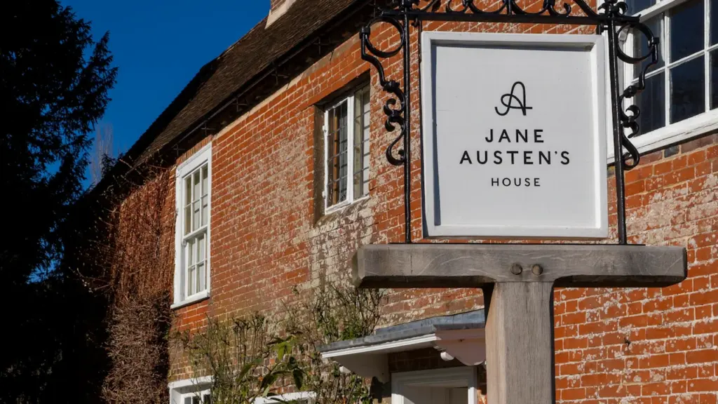 The historic brick exterior and sign of Jane Austen's House in Chawton, Hampshire.