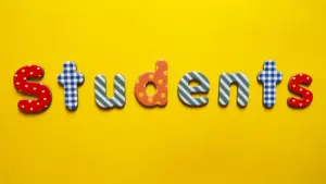 The word students spelled out using colorful decorative letters on a bright yellow background.