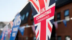 A British flag hanging from the side of a traditional brick building exterior.